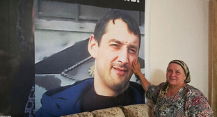 Эсет Умарова рядом с портретом своего сына Мовсара. Фото: https://t.me/no_torture/3635